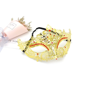 Detail of golden metal masquerade mask with red rhinestones and elastic head band