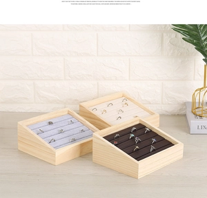 Macro detail of solid wood ring display tray with multi-tier slots and velvet lining
