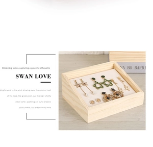 Macro view of assorted gold earrings with pearls and stars in a wooden display tray