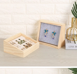Detail of wooden slanted earring display tray with grey velvet lining for jewelry storage