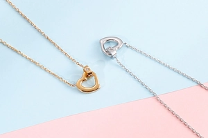 Detailed close-up of hollow heart pendants in polished gold and silver stainless steel