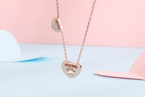 Dettaglio del ciondolo a cuore in oro rosa con impronta di zampa traforata sulla collana