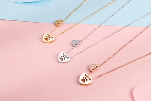 Tre collane in oro, argento e oro rosa con ciondoli a forma di zampa e cuore cavo