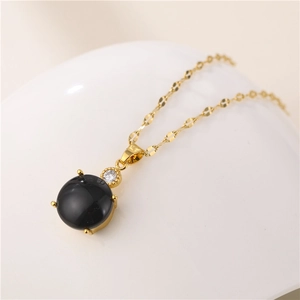 Golden teardrop titanium necklace with color-changing stone and sparkling zircon pendant