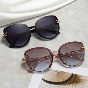 Fashionable women's oversized cat-eye sunglasses in black and translucent pink gradient frames