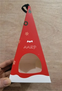 Red Christmas triangle gift box with window and black ribbon on wood background