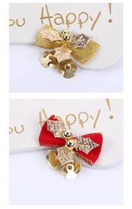 Close-up of red velvet and gold fabric Christmas bows with festive bells and leaves