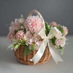 Handwoven flower basket with pink silk roses, pompom mums and a white satin bow detail