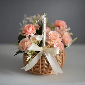 Close-up of a woven flower basket with pink roses and a delicate cream satin bow decoration