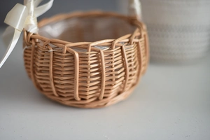 Macro detail of hand-woven wicker basket with waterproof liner and white silk ribbon bow