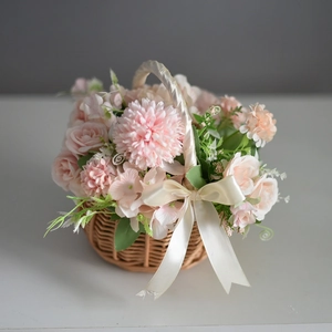 Detail of hand-woven wicker flower basket with pink artificial roses and cream ribbon