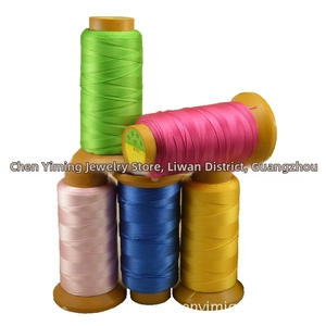 Detailed view of colorful 6-ply polyester beading threads on brown plastic spools