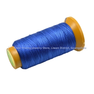 Macro shot of bright blue polyester braiding cord wound on an orange plastic spool
