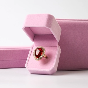 Red pear-cut gemstone gold ring with white diamond halo and pink velvet jewelry box