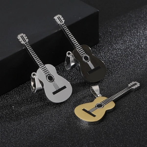 Guitar pendants in silver, gold, and black finishes on a textured surface