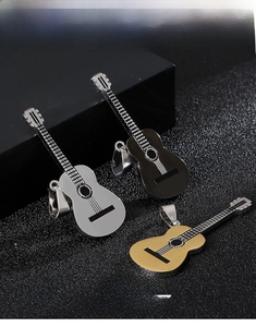 Close-up of guitar pendants in silver, gold, and black with detailed etchings