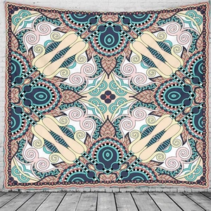 Detail of bohemian tapestry with symmetric paisley pattern on white brick wall