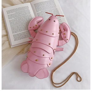Detailed view of pink lobster-shaped crossbody bag with gold rivet texture and chain