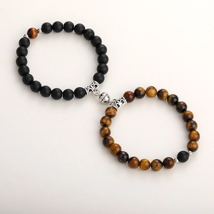 Detail of couple bracelets with tiger eye beads and heart-shaped magnetic alloy clasp
