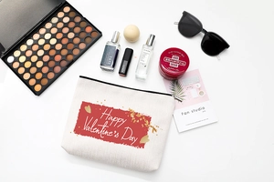 Close-up of cream canvas makeup bag with Happy Valentine's Day print and gold zipper