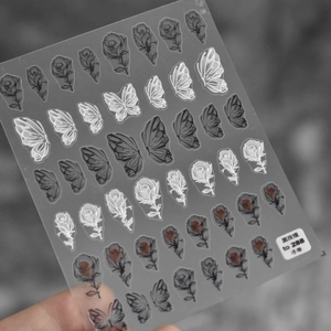 Détail de stickers à ongles 5D en relief avec motifs de roses noires et papillons
