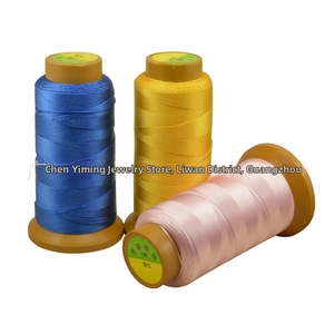Detailed view of high-strength 3-ply polyester jewelry threads in blue, yellow, and pink
