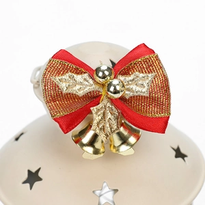 Mini nœud de Noël rouge avec cloches dorées et feuilles de houx sur décor céramique