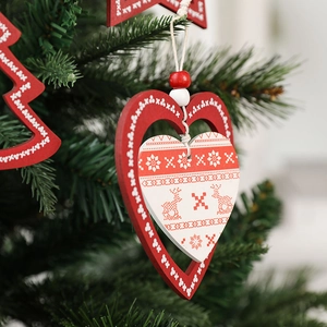 Nordic wooden Christmas ornaments with snowflake and reindeer hanging on a tree branch