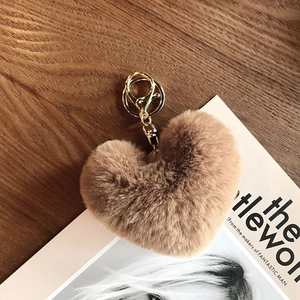 Detail shot of heart-shaped leopard plush keychain with golden lobster clasp and metal ring