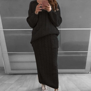 Détail d'un ensemble tricoté noir torsadé avec pull et jupe mi-longue pour femmes