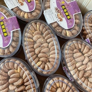 Macro shot of 200g containers filled with premium skin-on salt-baked cashew nuts