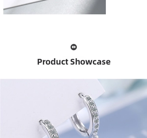 Detailed macro view of silver hoop earrings with white zircon stones on a display card