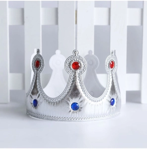 Detail of silver fabric king crown with red and blue gems for birthday party cake topper