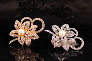 Close-up of gold and silver flower brooches with rhinestones and large pearls