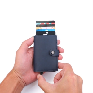 Macro shot showing blue leather card holder with pop-up mechanism and card storage
