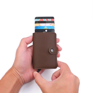 Brown leather wallet detail with pop-up card mechanism and secure snap closure