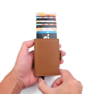 Brown PU leather pop-up card holder showing hand-operated card ejecting mechanism