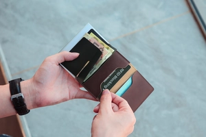Detail of silver metal and brown leather RFID blocking card holder with pop-up mechanism