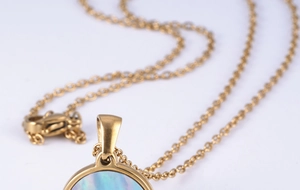 Detail of 18K gold stainless steel necklace with round blue shell letter pendant