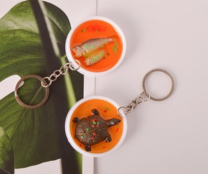 Close-up of creative PVC fake food fish soup and turtle model keychains with metal rings