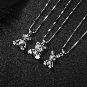 Close-up of vintage silver bear and rabbit pendants on titanium steel box chains