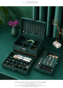 Detailed interior of dark green velvet jewelry box showing ring slots and necklace hooks