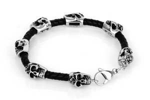 Detail of black braided leather punk bracelet featuring silver skull and rose charms