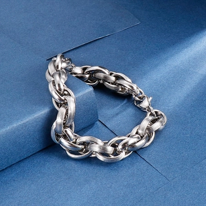 Close-up of silver steel chain bracelet with textured links on geometric background