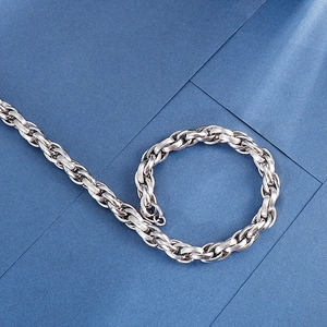 Minimalist silver stainless steel O-chain necklace set on a blue geometric background