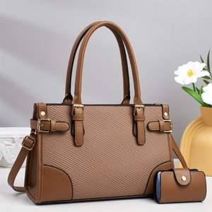 Detail view of brown faux leather and woven fabric tote bag with gold metal buckle