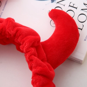 Gros plan détaillé du serre-tête rouge en peluche avec cornes de diable sur fond blanc