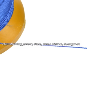 Close-up of blue braided polyester thread for jewelry making on yellow plastic spool