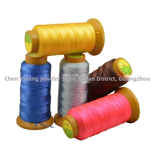 Close-up of five colorful high-strength polyester thread spools for jewelry making and DIY