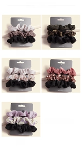 Detail of assorted fabric scrunchies in leopard print and floral patterns on card